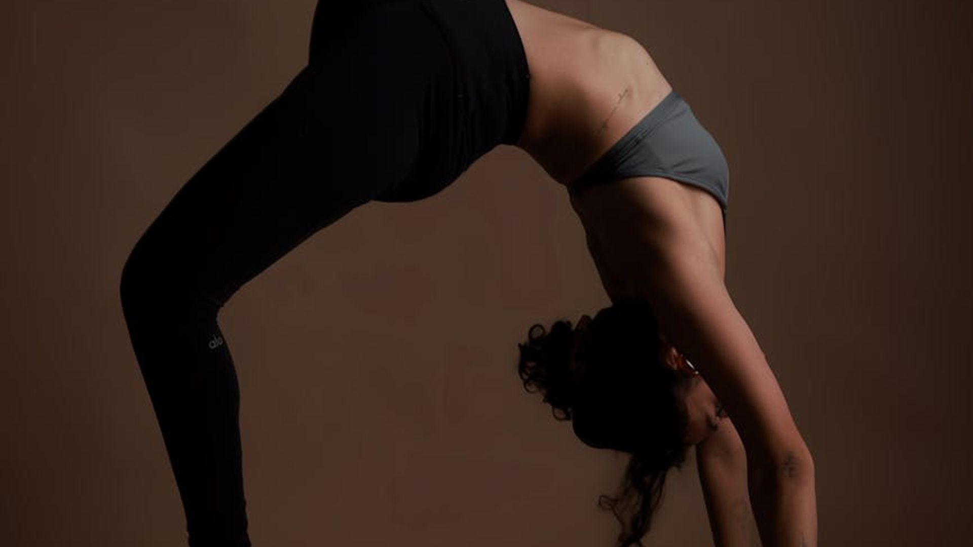 Person practicing yoga in a dark studio with neon light